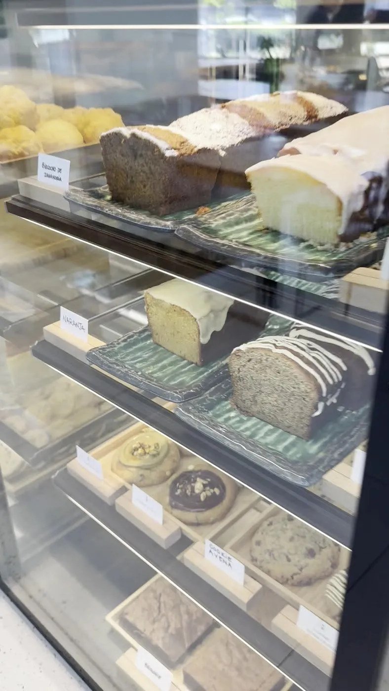Vitrina con plumcakes en porciones, galletas y etiquetas blancas